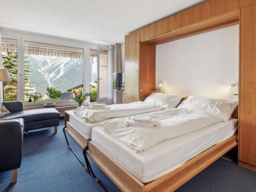 a bedroom with two beds and a large window at Apartment Promenade - Utoring-68 by Interhome in Arosa