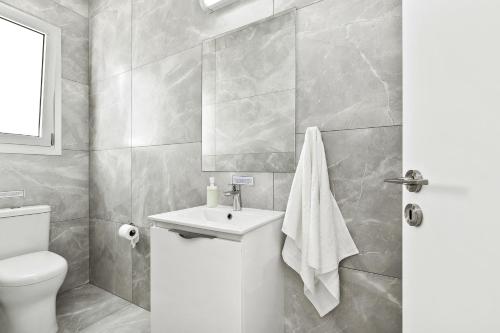 a bathroom with a white toilet and a sink at Sea Point Villas Luxury Villas with Private Pools in Coral Bay in Coral Bay