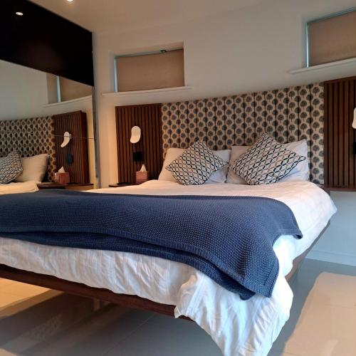 a bedroom with a large bed with blue sheets and pillows at The Shutter House in Compton