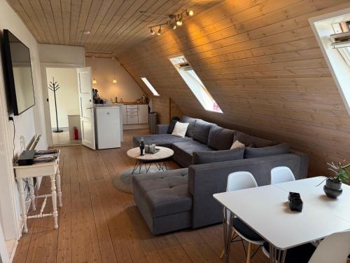 a living room with a couch and a table at Penthouse apartment in Esbjerg townhouse in Esbjerg