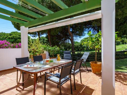 einen Tisch und Stühle auf einer Terrasse mit einer Pergola in der Unterkunft Holiday Home Las lomas de Cabopino by Interhome in Marbella