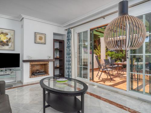 ein Wohnzimmer mit einem Glastisch und einem Kamin in der Unterkunft Holiday Home Las lomas de Cabopino by Interhome in Marbella