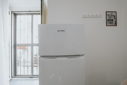a white refrigerator in a room with a window at Noah&Chris Apartments in Bitritto