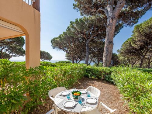 une table et des chaises sur une terrasse avec un arbre dans l'établissement Apartment Les Coteaux de la Nartelle-28 by Interhome, à Sainte-Maxime