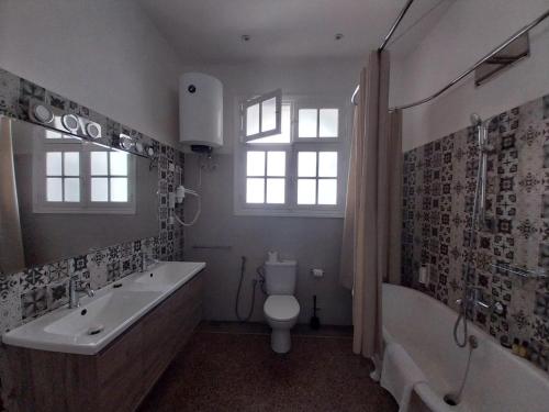 a bathroom with a tub and a toilet and a sink at Appartements Balima Harcourt DeLuxe in Rabat