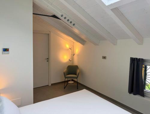 a bedroom with a chair in a room with white walls at Urban Living in Como