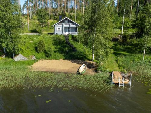 a house on the shore of a lake with a boat at Holiday Home Eteläranta by Interhome in Hara