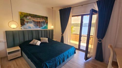 a bedroom with a green bed and a large window at Casa Elaria in Sviniţa
