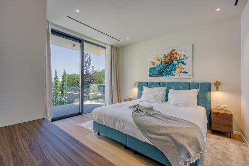 a bedroom with a large bed and a large window at Petram Resort & Residences in Savudrija