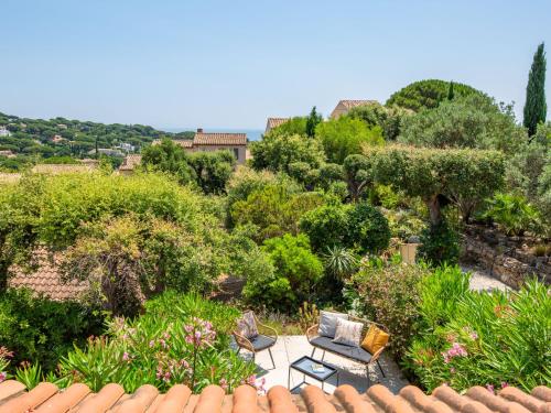 Elle offre une vue sur un jardin avec des chaises et des arbres. dans l'établissement Holiday Home Les Bastides de Guerrevieille-7 by Interhome, à Sainte-Maxime