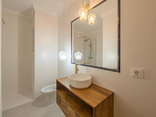 Un baño blanco con lavabo y espejo. en Serpentona Apartments, en Cala Galdana