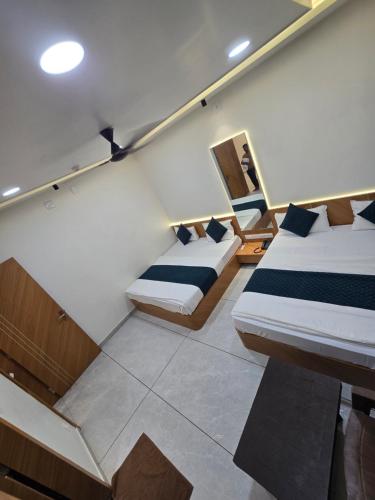 two beds in a room with a staircase at Hotel somtirth in Somnath