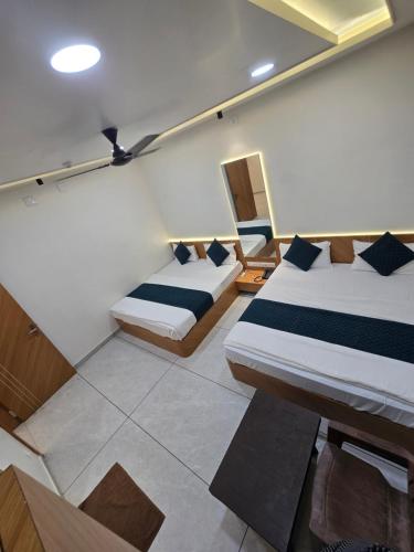 a bedroom with two beds in a room at Hotel somtirth in Somnath