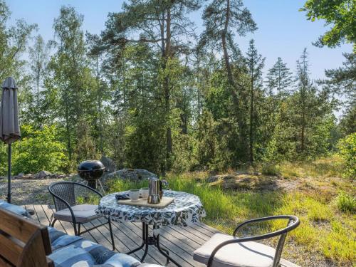 a patio with a table and chairs in the woods at Holiday Home Ekbacken by Interhome in Stjärnhov