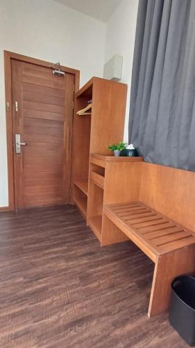a room with a wooden closet with a wooden door at Sling & Stone Mountain Suites in Kundasang