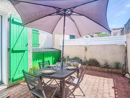 - une table avec un parasol violet sur la terrasse dans l'établissement Holiday Home Les Conches by Interhome, à Saint-Georges-dʼOléron