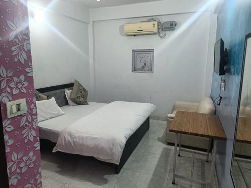 a small room with a bed and a table at Hotel Downtown in Meerut
