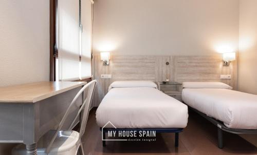 a hospital room with two beds and a desk at Hotel Playa Poniente in Gijón