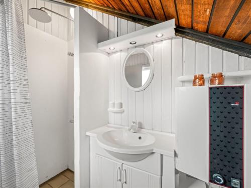 a white bathroom with a sink and a mirror at Holiday Home Hildegart - from the sea by Interhome in Bjerregård