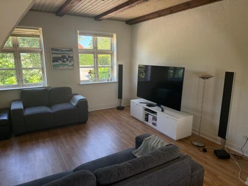 a living room with a couch and a flat screen tv at Hus ved Svendborg in Svendborg