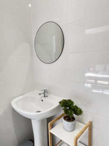 une salle de bain blanche avec un lavabo et un miroir dans l'établissement Studio B3 - Centre-Ville Meaux - Proche Disneyland, à Meaux