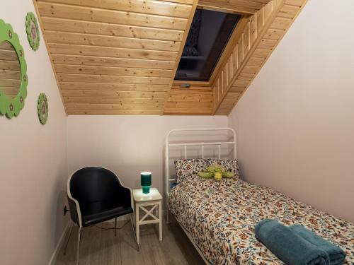 a small bedroom with a bed and a chair at Pod Lasem Apartamenty in Łukęcin