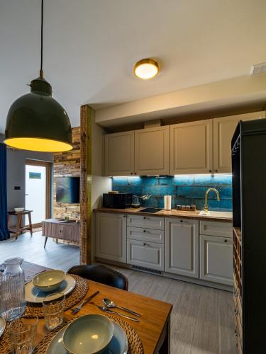 a kitchen with a table with plates on it at Pod Lasem Apartamenty in Łukęcin