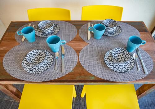a wooden table with plates and blue cups on it at Maison du charme Gourdon in Gourdon-en-quercy