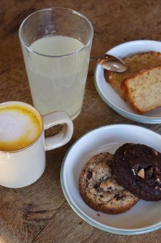 une table avec des assiettes de biscuits et une tasse de lait dans l'établissement Le Domaine de Courances - Pierres d'Histoire, à Courances