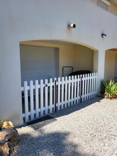 a white fence in front of a garage at Location gîte dans le var in Le Thoronet