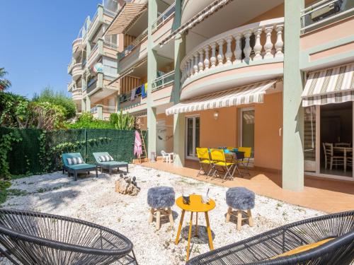 un patio avec des chaises et des tables devant un bâtiment dans l'établissement Apartment Le Maxime Park Résidence by Interhome, à Sainte-Maxime