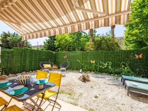 une terrasse avec une table et des chaises sous un parasol en bois dans l'établissement Apartment Le Maxime Park Résidence by Interhome, à Sainte-Maxime