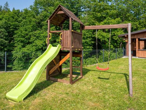 a playground with a slide and a swing at Apartment Maklen-2 by Interhome in Brod Moravice