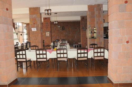 a dining room with a white table and chairs at Panoramic View Hotel in Lalībela