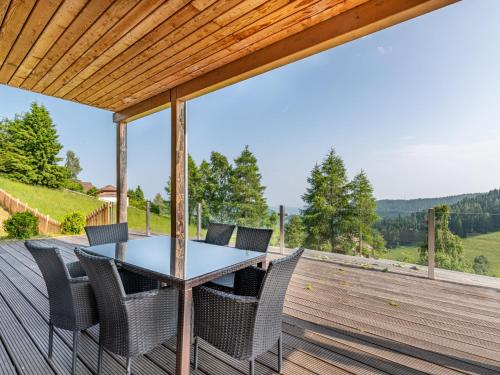 um pátio com uma mesa e cadeiras em um deck em Apartment Simonhöhe Kärntentraum-1 by Interhome em Sankt Paul