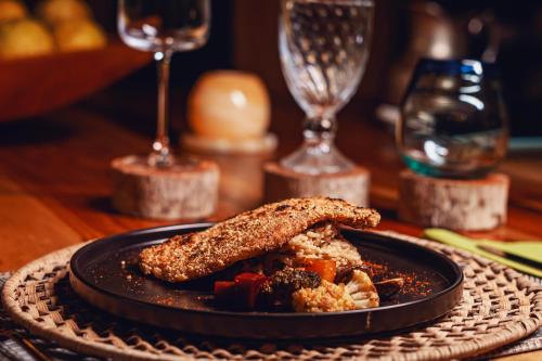 a black plate with a piece of food on a table at Burú Nature Hotel in Leticia