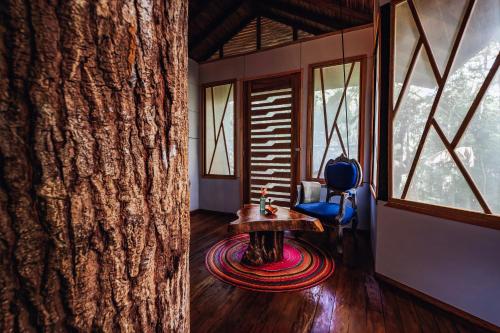 a room with a table and a chair and windows at Burú Nature Hotel in Leticia