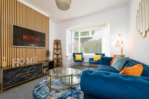 a living room with a blue couch and a tv at Luxury House - Pool Table - Parking - Brand New in Little Coates