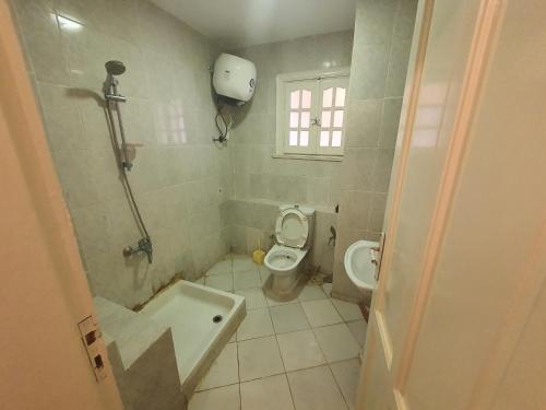 ein Badezimmer mit Toilette und Badewanne in der Unterkunft Chalet Marina Flowers Resort in El-Alamein