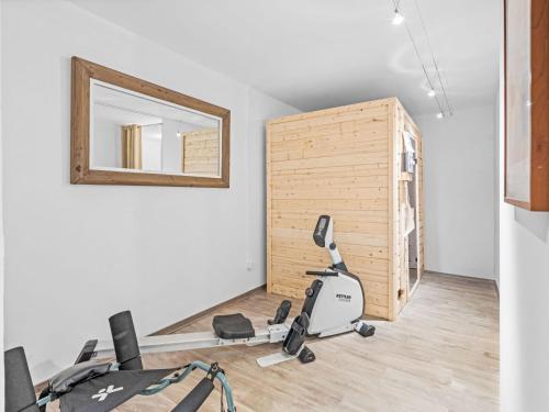Cette chambre comprend un vélo d'appartement et un miroir. dans l'établissement Apartment Jeanne D'Arc LOFT Montagne by Interhome, à Crans-Montana