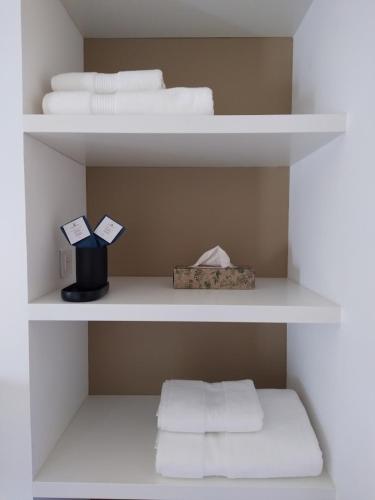 a white shelf with towels and a box on it at Maison La Petite Cour - Spa in Visan