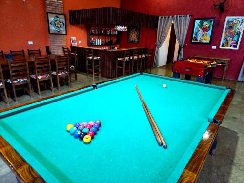 a pool table with a cue and balls on it at EcoNicolla Iguaçu Club House in Foz do Iguaçu