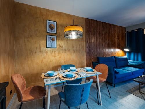a living room with a table and chairs and a couch at Pod Lasem Apartamenty in Łukęcin