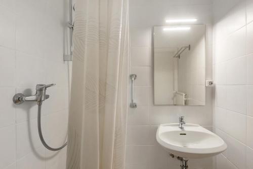 a white bathroom with a sink and a shower at db staycation ferienpark in Niedenstein