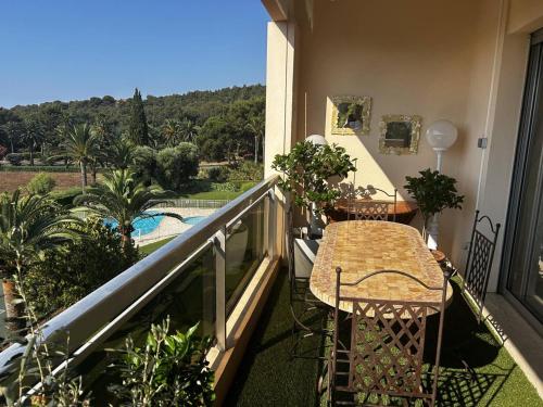 d'un balcon avec une table et une vue sur la piscine. dans l'établissement Bel appartement avec terrasse et vue mer à Cavalaire-sur-Mer - FR-1-100-361, à Cavalaire-sur-Mer
