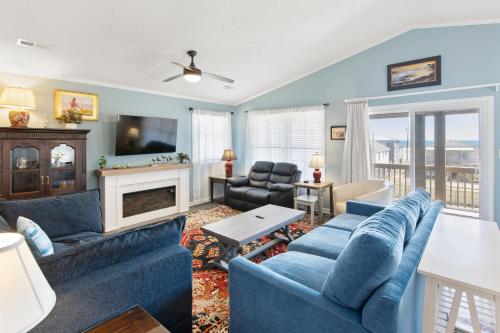 a living room with blue furniture and a fireplace at Swallows Nest in Kitty Hawk