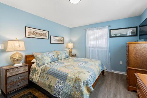 a bedroom with blue walls and a bed and a dresser at Swallows Nest in Kitty Hawk
