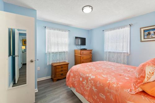 a bedroom with blue walls and a bed and a mirror at Swallows Nest in Kitty Hawk