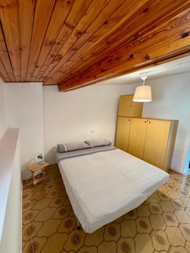 a bedroom with a bed and a wooden ceiling at Casa Altolaterra in Tagliacozzo
