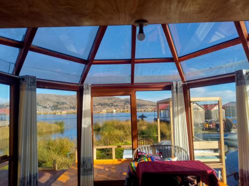 a glass house with a view of the water at Uros Titicaca coila lodge in Puno